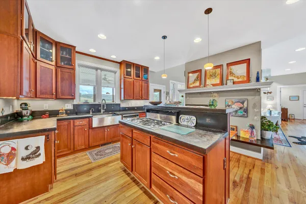 a kitchen with stainless steel appliances granite countertop a sink stove and wooden cabinets