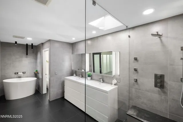 a bathroom with a double vanity sink mirror and bathtub