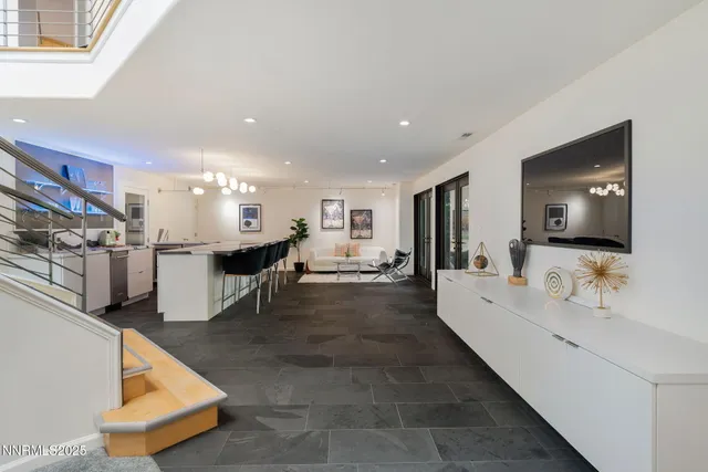 a living room with stainless steel appliances kitchen island furniture and a flat screen tv