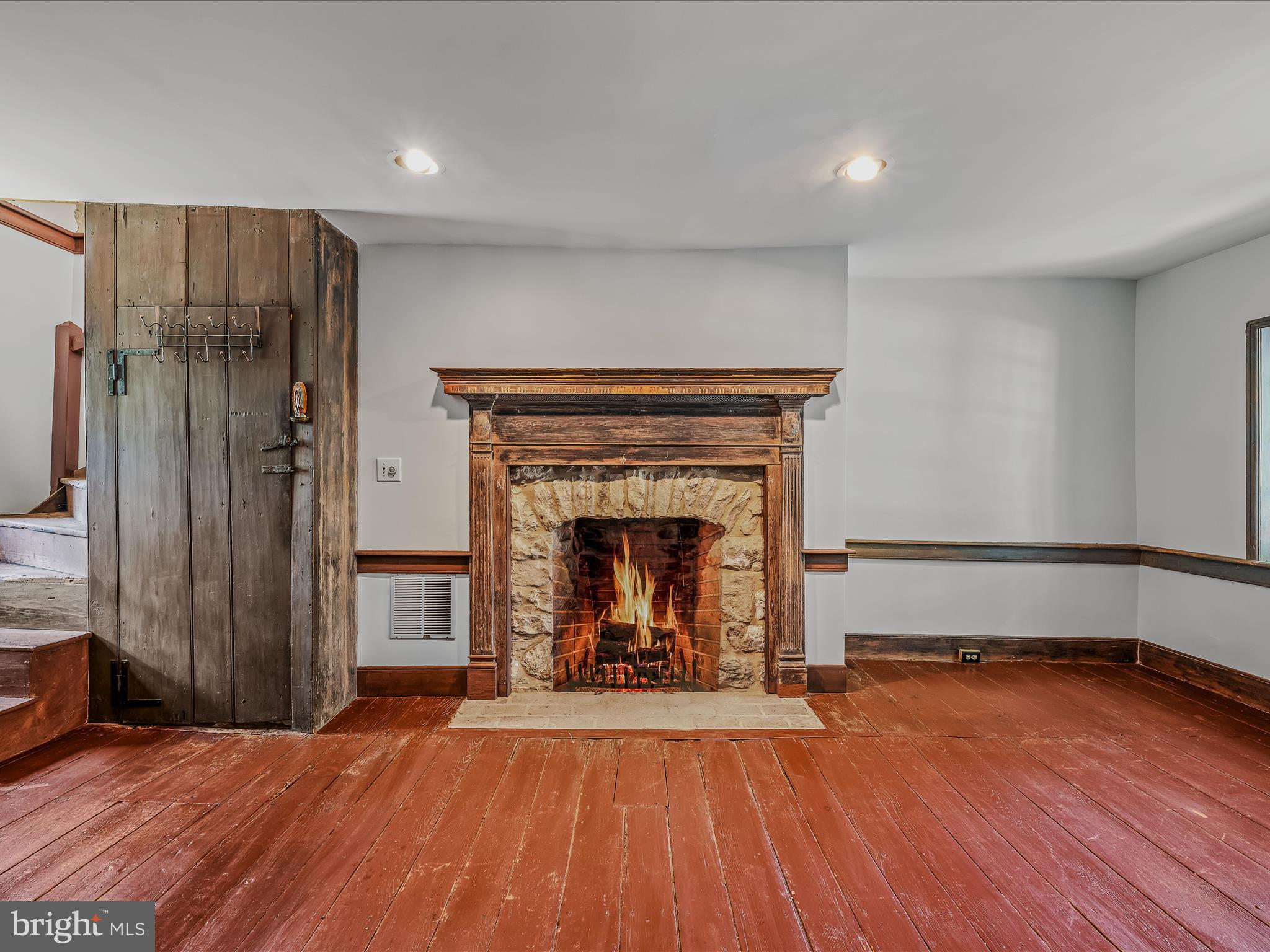 1646 Gerrardstown Road Gerrardstown, WV 25420 - Photo 6 of 37 a view of an empty room with wooden floor fireplace and a window