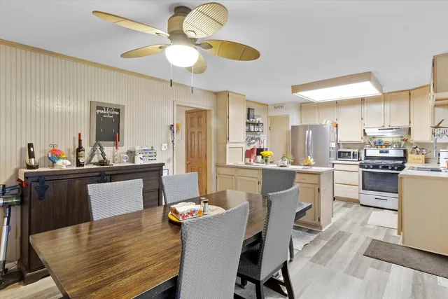 a kitchen with a dining table chairs refrigerator and cabinets