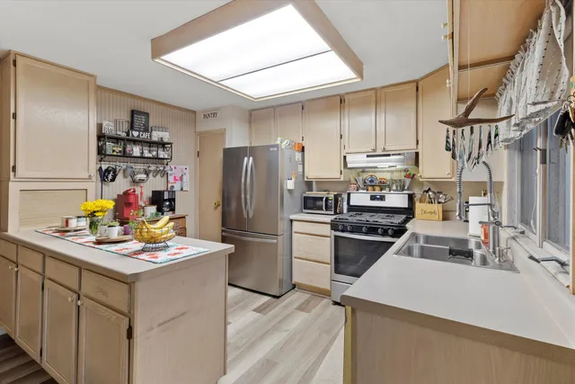 a kitchen with a refrigerator a stove a sink dishwasher and a refrigerator