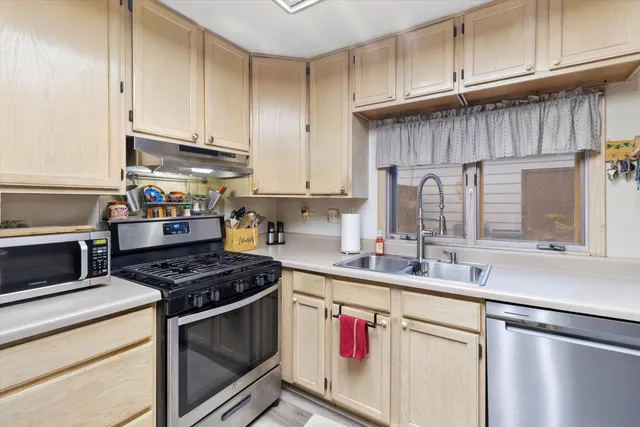 a kitchen with stainless steel appliances granite countertop a sink stove and cabinets