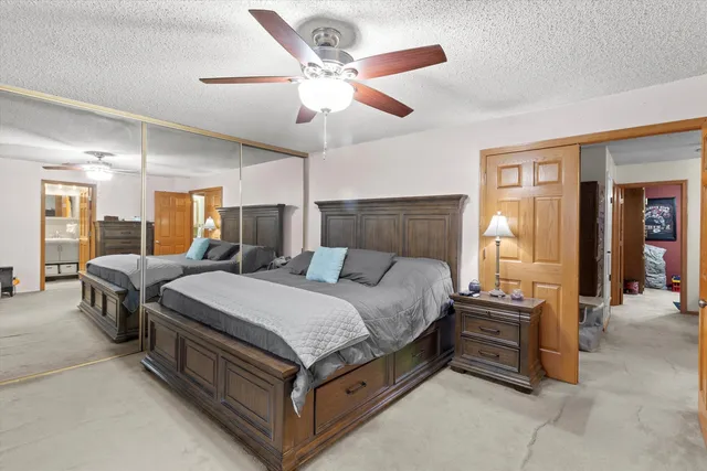 a spacious bedroom with a bed and ceiling fan