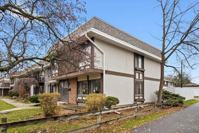 a view of a white house with a large tree and windows