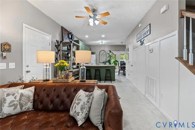 a living room with furniture a fireplace and a chandelier