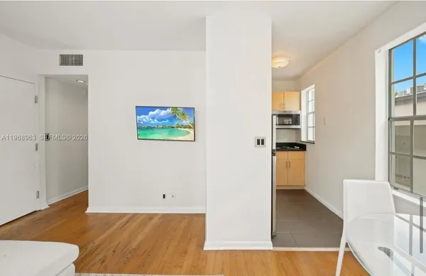 a view of a kitchen with wooden floor and a living room