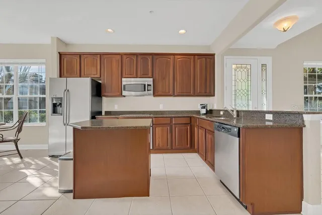 a kitchen with stainless steel appliances granite countertop a refrigerator and a stove top oven
