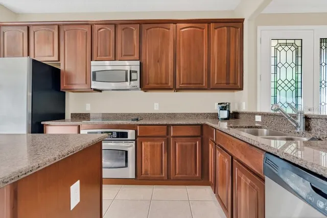 a kitchen with stainless steel appliances granite countertop a stove a sink dishwasher and a microwave oven with cabinets