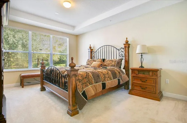 a spacious bedroom with a bed and a dresser next to a window