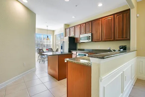 a kitchen with stainless steel appliances granite countertop a refrigerator a stove and a sink