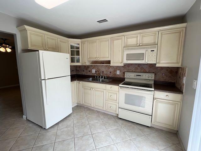 1611 Johnson Street, Unit 2 Lake Worth Beach, FL 33460 - Photo 2 of 12 a kitchen with cabinets and a refrigerator