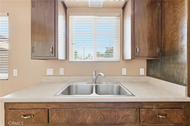 a kitchen with stainless steel appliances granite countertop a sink window and cabinets