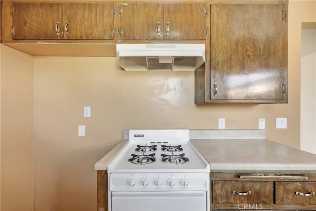 a white stove top oven sitting inside of a kitchen