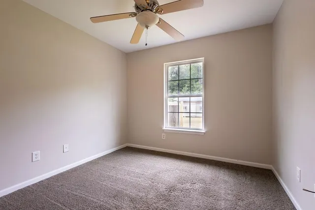 an empty room with a window and a fan