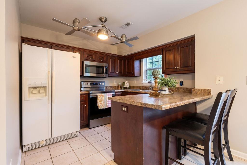 33 Northwest Hunters Glenn Road Northwest Rome, GA 30165 - Photo 3 of 19 a kitchen with stainless steel appliances granite countertop a refrigerator a sink dishwasher a stove with a dining table and chairs
