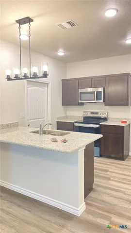 a kitchen with kitchen island a sink appliances and cabinets