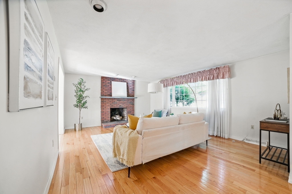 8 Ware Road Winchester, MA 01890 - Photo 2 of 25 a living room with fireplace furniture wooden floor and a large window
