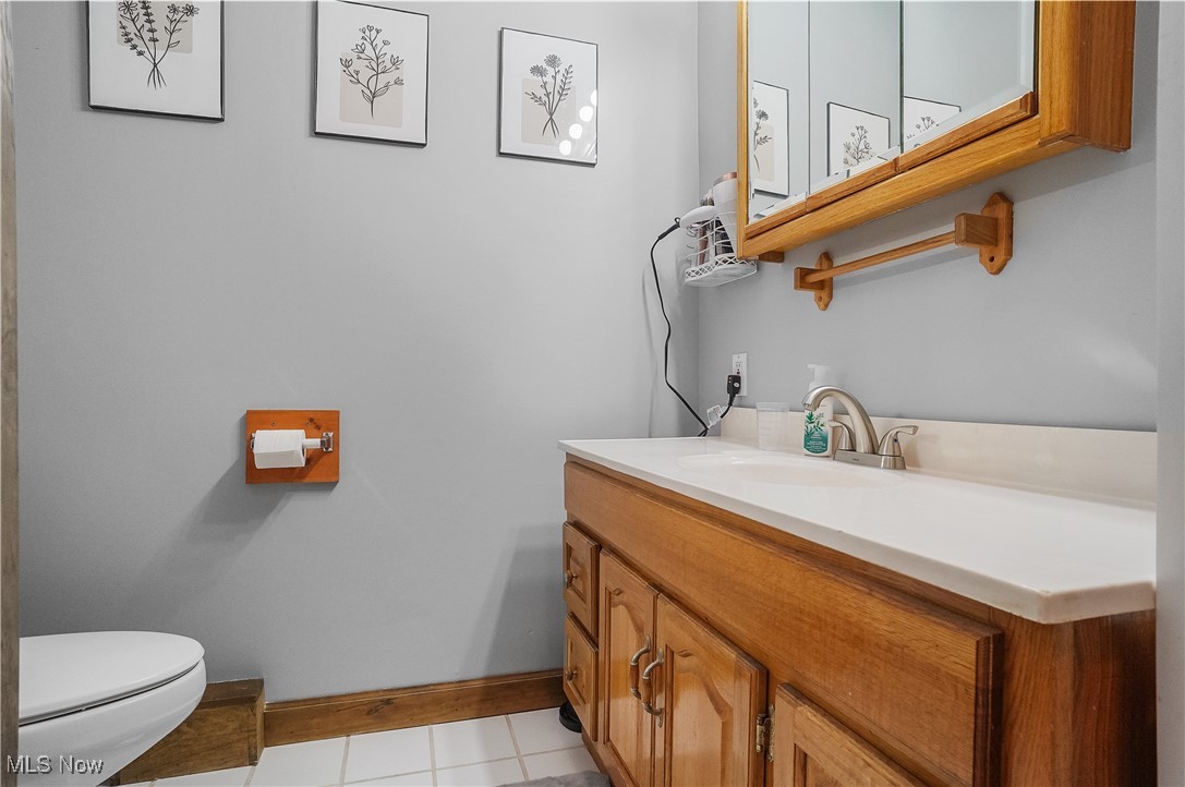 35977 Teegarden Road Salem, OH 44460 - Photo 22 of 50 Half bathroom featuring baseboards, toilet, vanity, and tile patterned floors