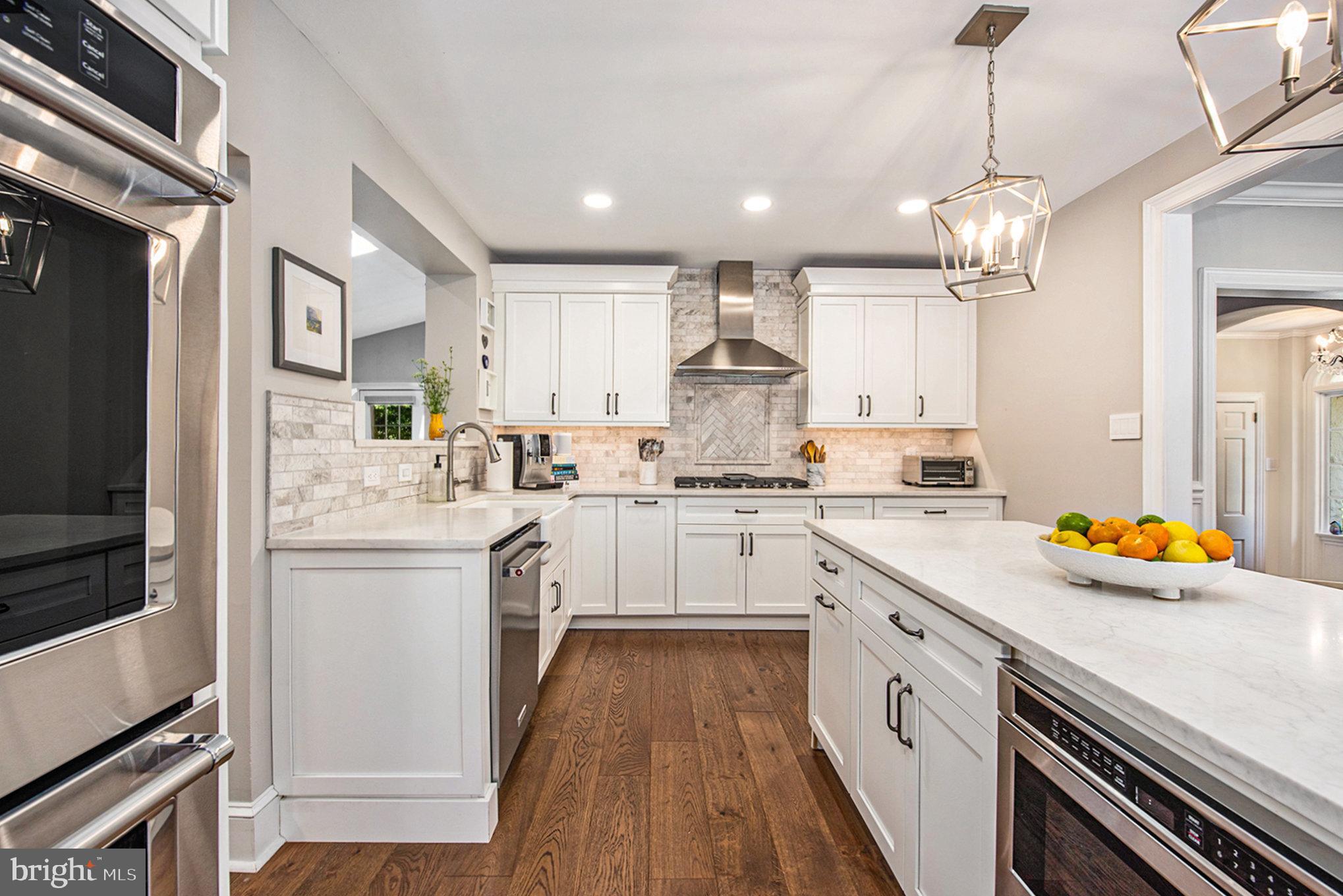 109 Willowburn Road Villanova, PA 19085 - Photo 19 of 65 a kitchen with white cabinets stainless steel appliances a sink and a stove