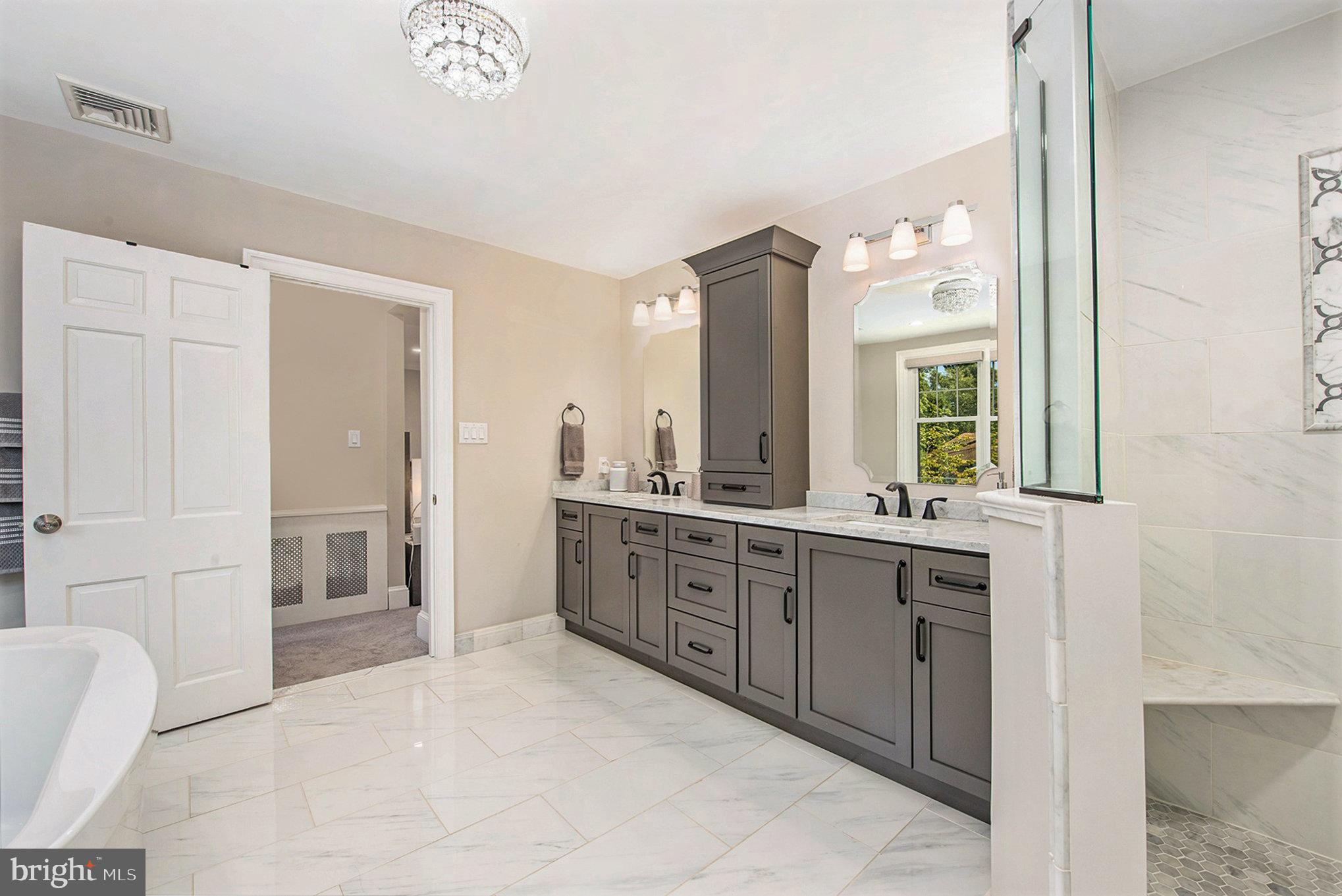 109 Willowburn Road Villanova, PA 19085 - Photo 36 of 65 a large bathroom with a double vanity sink a large mirror and a bathtub