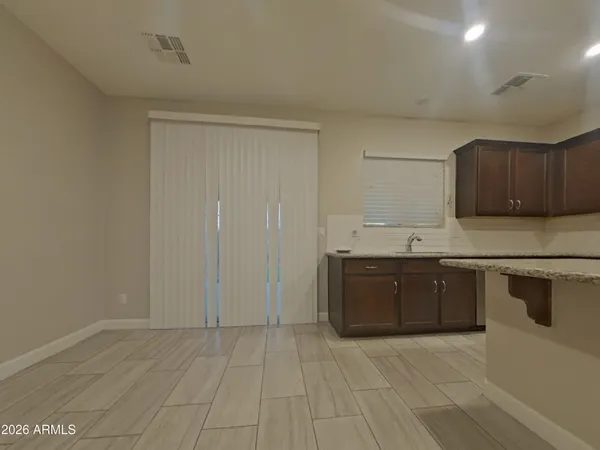 a view of an empty room and chandelier fan