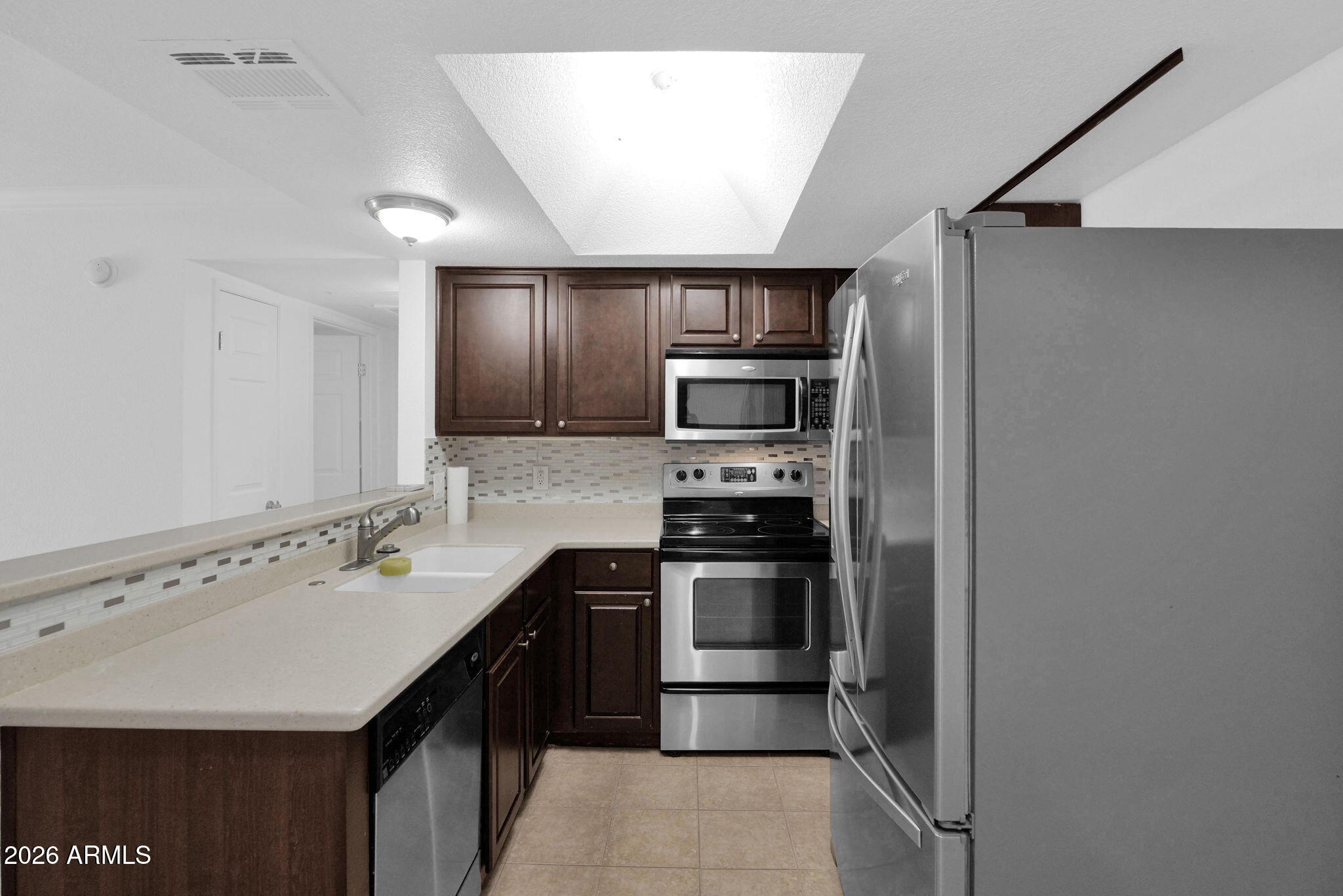 1720 East Thunderbird Road, Unit 1019 Phoenix, AZ 85022 - Photo 12 of 47 a kitchen with a sink stainless steel appliances and cabinets