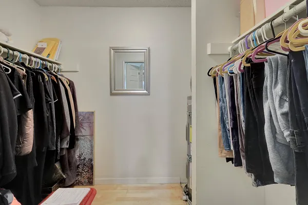 a view of walk in closet with clothes and shoes