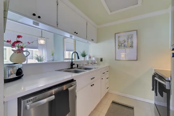 a kitchen with a sink dishwasher and cabinets with wooden floor