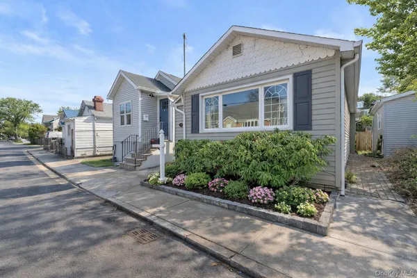 a front view of a house with a yard and potted plants
