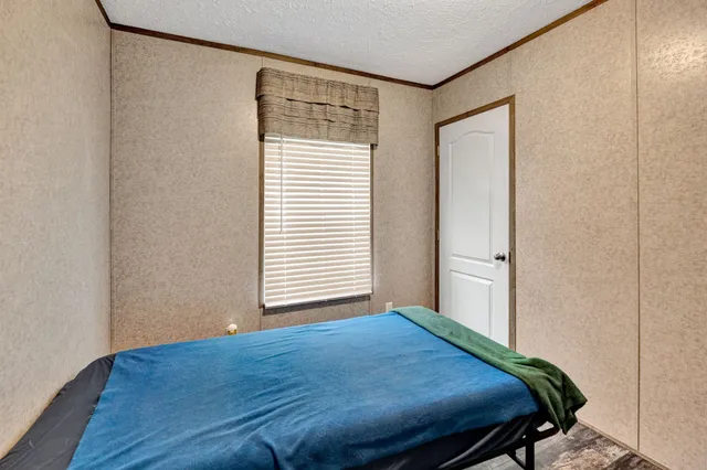 a bedroom with a bed and a painting on the wall