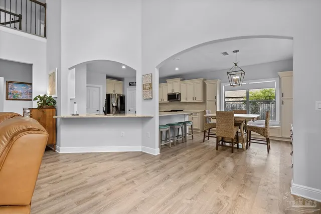 a living room with furniture a flat screen tv and kitchen view