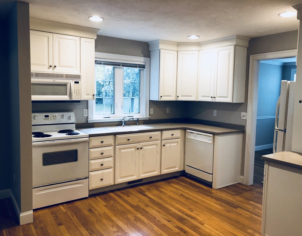 120 Summer Road, Unit 120 Boxborough, MA 01719 - Photo 2 of 6 a kitchen with stainless steel appliances granite countertop a stove a sink and white cabinets