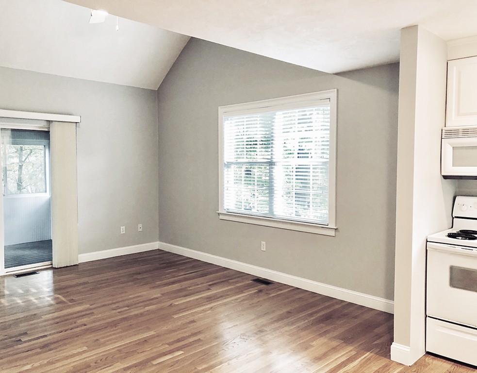 120 Summer Road, Unit 120 Boxborough, MA 01719 - Photo 4 of 6 an empty room with wooden floor and windows
