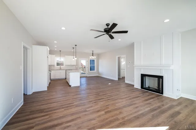 a view of a living room a kitchen with a fireplace and wooden floor