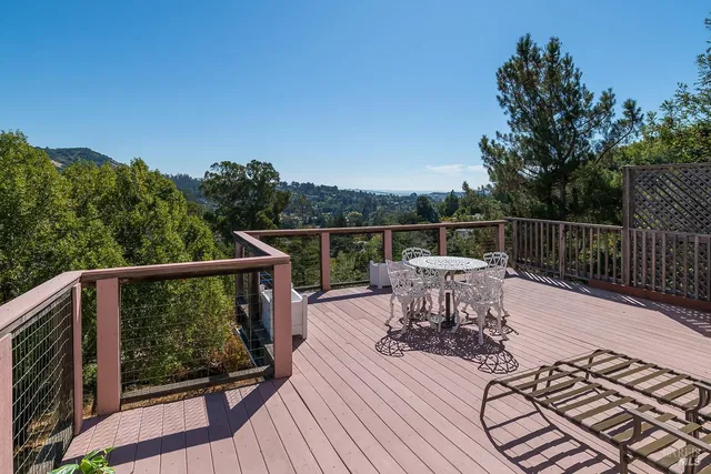 a view of a balcony with wooden floor and outdoor seating