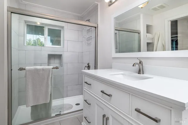 a bathroom with a shower sink and mirror