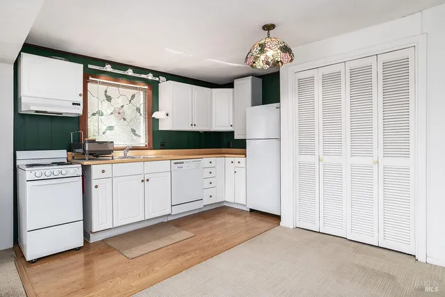 a kitchen with white cabinets and white appliances
