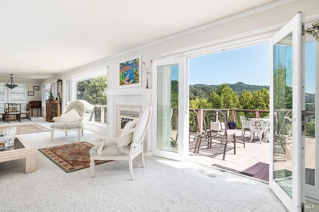 a living room with furniture a large window and a fireplace
