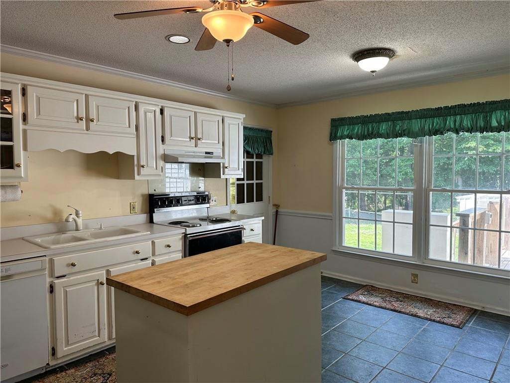 241 Olde Quarry Road Graham, NC 27253 - Photo 12 of 30 a kitchen with stainless steel appliances granite countertop a stove a sink dishwasher and white cabinets with wooden floor