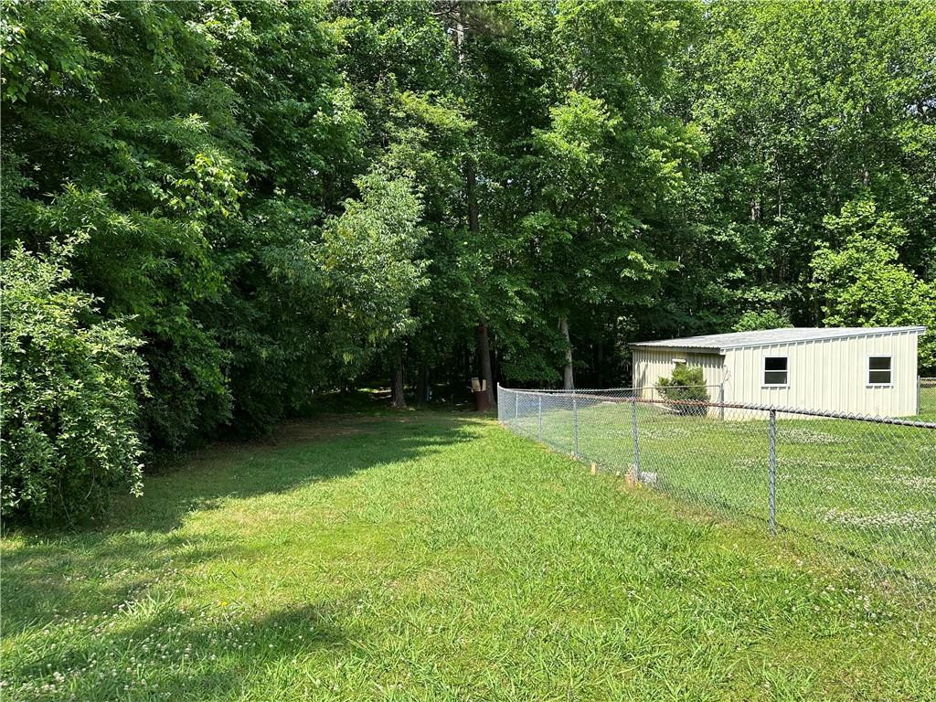 241 Olde Quarry Road Graham, NC 27253 - Photo 27 of 30 a backyard of a house with large trees and plants