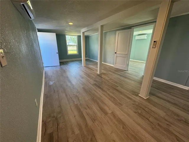 a view of an empty room with wooden floor and closet