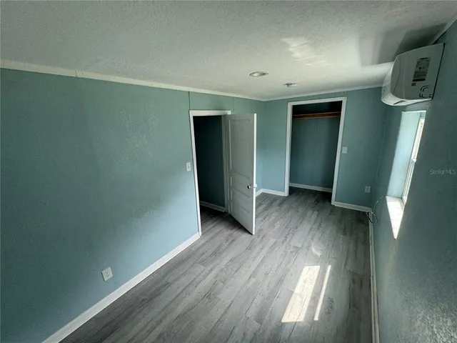 an empty room with wooden floor and entrance