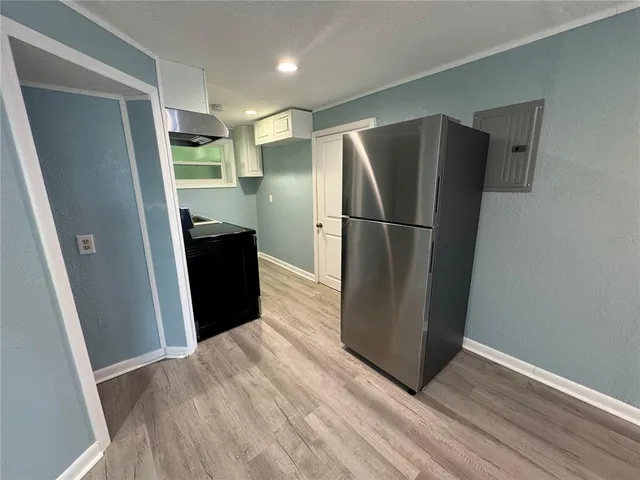 a view of a refrigerator in kitchen and wooden floor