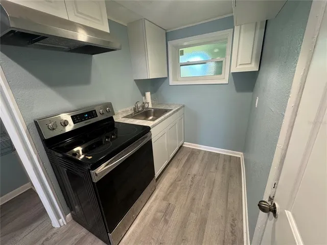 a kitchen with wooden floor and a stove