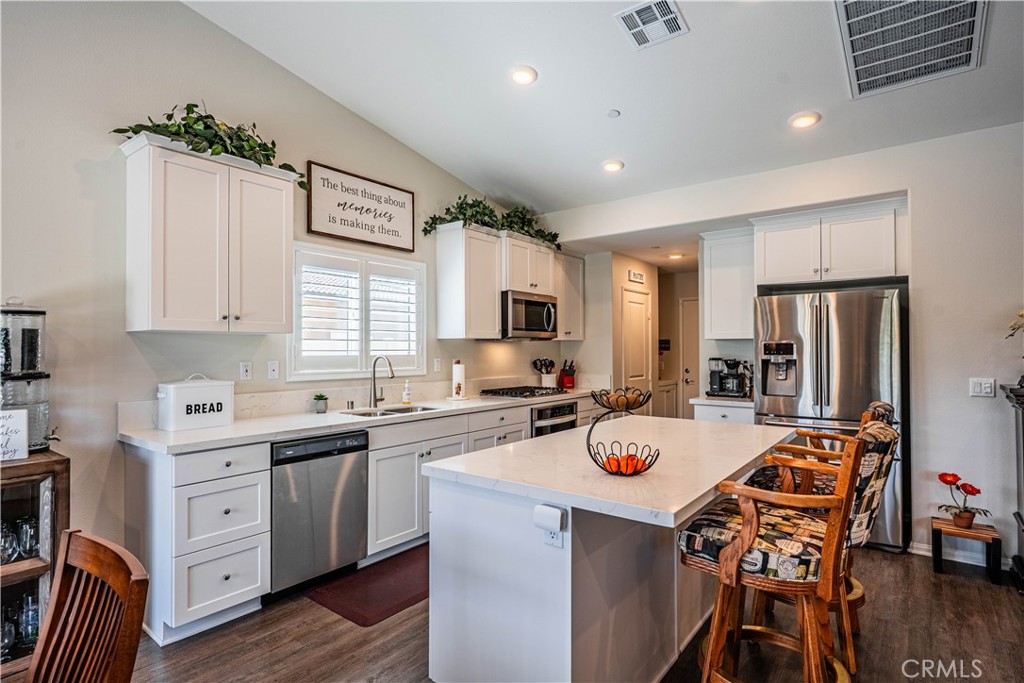 28340 Memory Lane Winchester, CA 92596 - Photo 12 of 39 a kitchen with a refrigerator a stove a sink dishwasher with a dining table and chairs