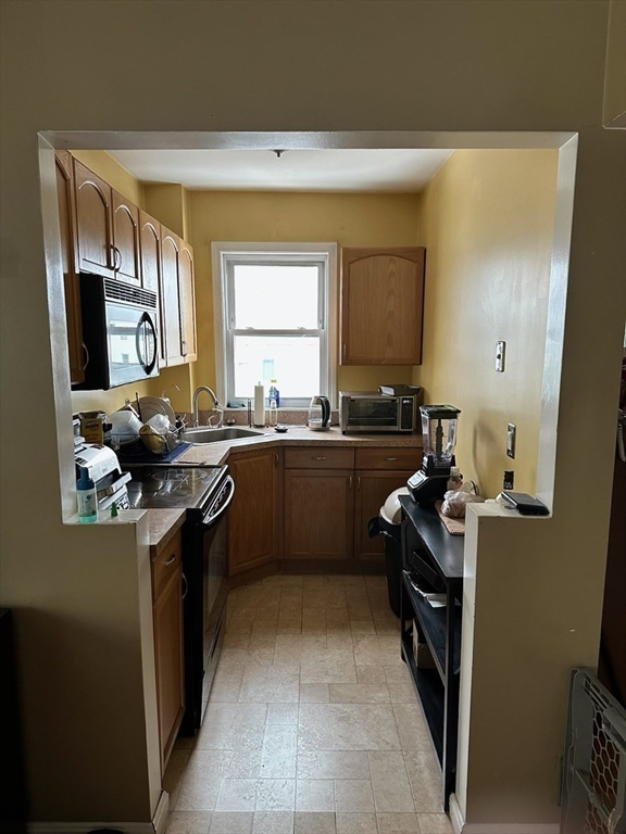166 Bradford Avenue Fall River, MA 02721 - Photo 12 of 28 a kitchen with a sink stove and refrigerator