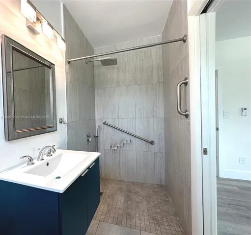 a bathroom with a sink mirror and shower