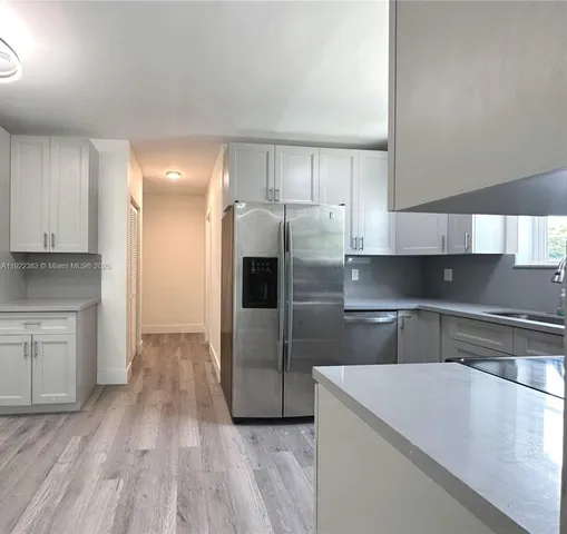 a kitchen with kitchen island a counter top a stove and a refrigerator