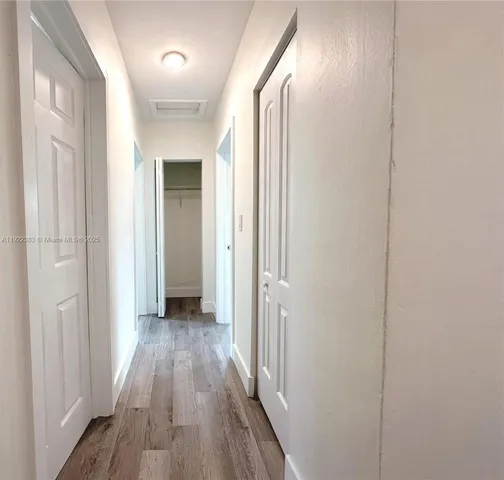 a view of a hallway with wooden floor